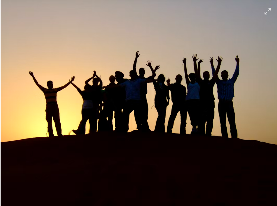 People standing together in silhouette at sunset